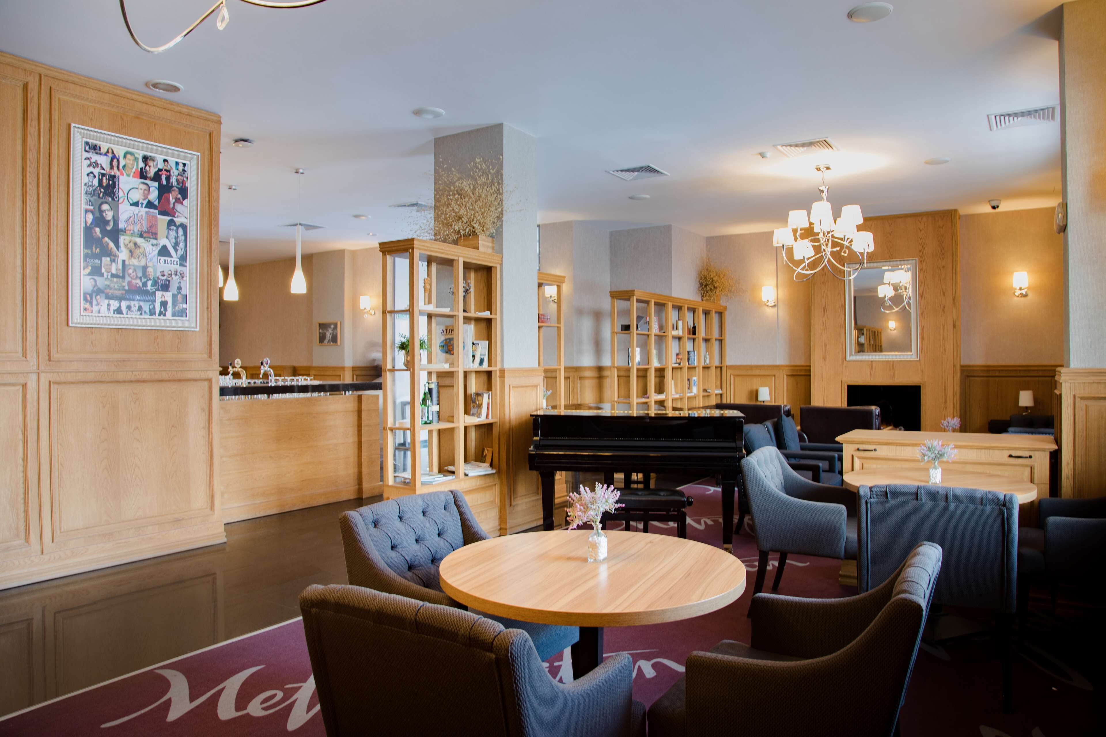 Eine Lobby mit einem Flügel, einer Sitzecke und einer Rezeption.