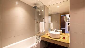 A modern bathroom with a glass-enclosed shower, two sinks, and a large mirror.