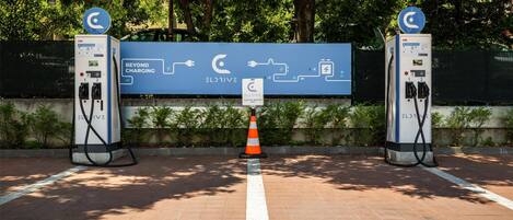 Une borne de recharge pour véhicules électriques, avec une signalétique indiquant les services « Beyond Charging » et « Eldrive ».