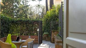 A patio with wicker furniture and a potted plant.