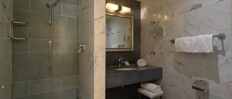 Une salle de bain moderne avec une douche à parois de verre, un lavabo avec un miroir et un porte-serviettes.