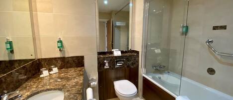 Une salle de bain moderne avec un lavabo en marbre, des toilettes et une douche en verre avec un pommeau de douche amovible.