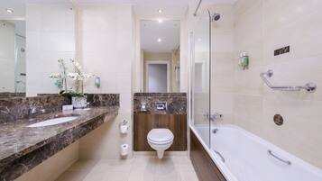 Un baño moderno con dos lavamanos, inodoro y bañera.