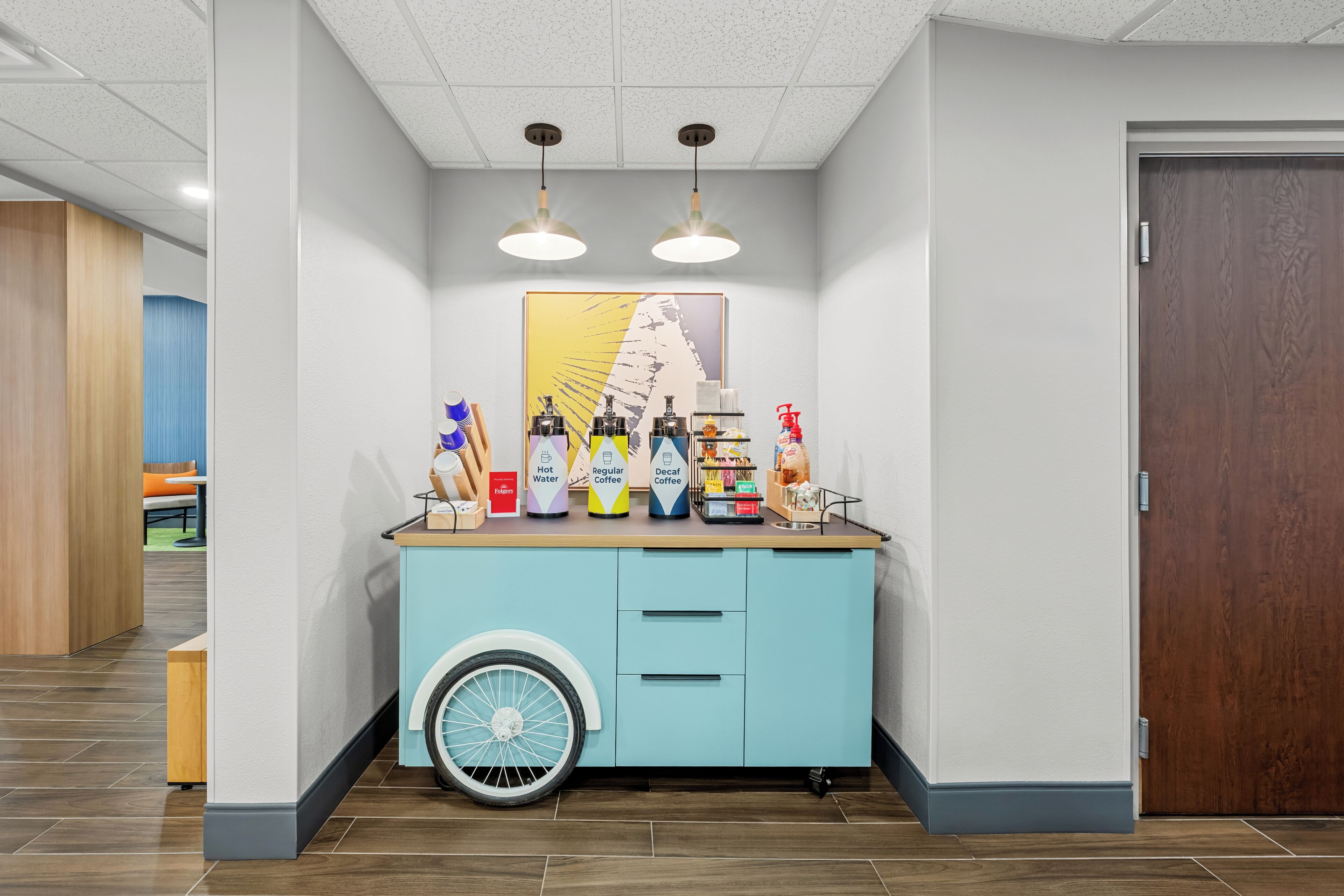 A counter with a fan, a mirror, and various items including a coffee machine and a bottle of water.