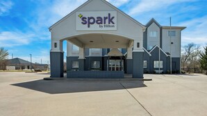 A hotel entrance with a sign reading 'spark by Hilton,' a covered entryway, and a parking lot. - Spark by Hilton Stillwater (Stillwater)