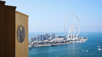Eine Küstenstadt mit einem markanten Riesenrad, Hochhäusern und einem Strand.