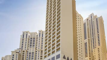 A tall hotel with multiple floors, featuring a prominent vertical design and a large entrance with a covered area.