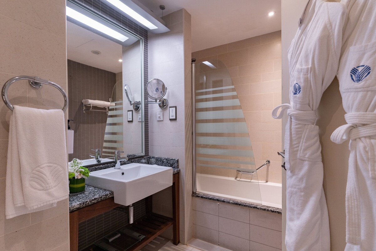A modern bathroom with a sink, mirror, and shower.