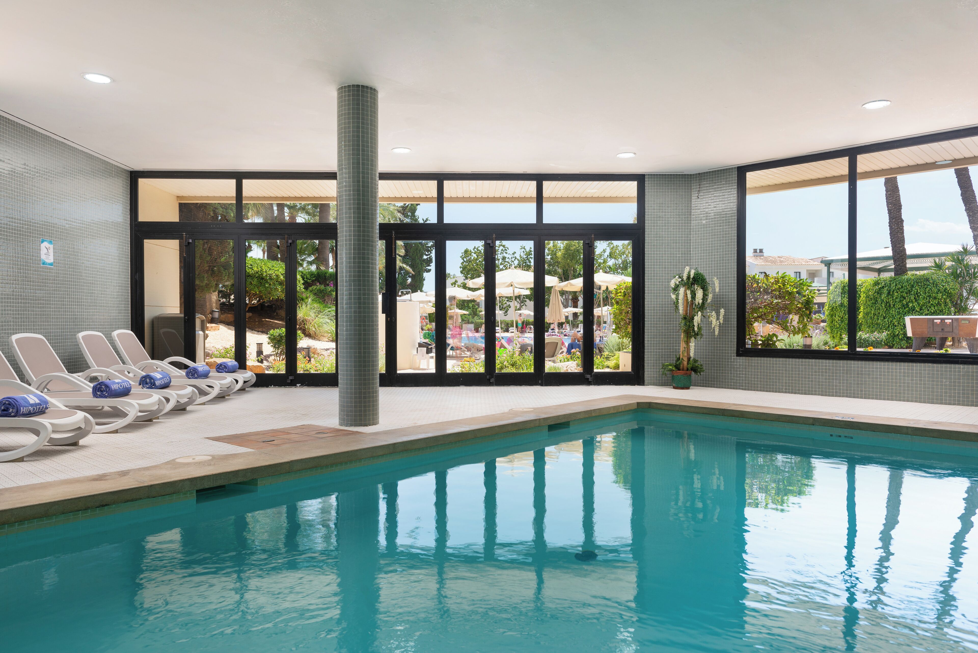Piscine intérieure, piscine extérieure en saison, parasols