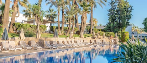 Una piscina cubierta, una piscina al aire libre de temporada, sombrillas