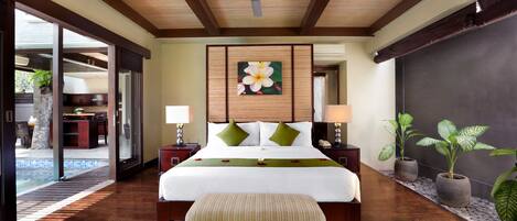 A spacious bedroom with a large bed, a ceiling fan, and a view of a pool area.