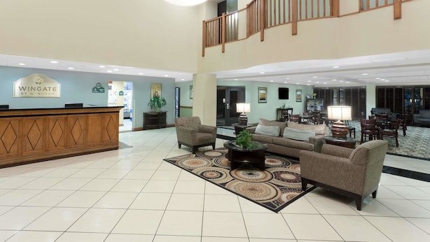 A spacious lobby with a reception desk, seating area, and a staircase. - Wingate by Wyndham Yuma (Yuma)