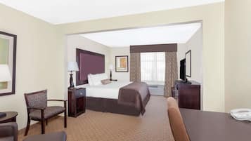 Een hotelkamer met een bed, bureau, stoel, televisie en telefoon.
