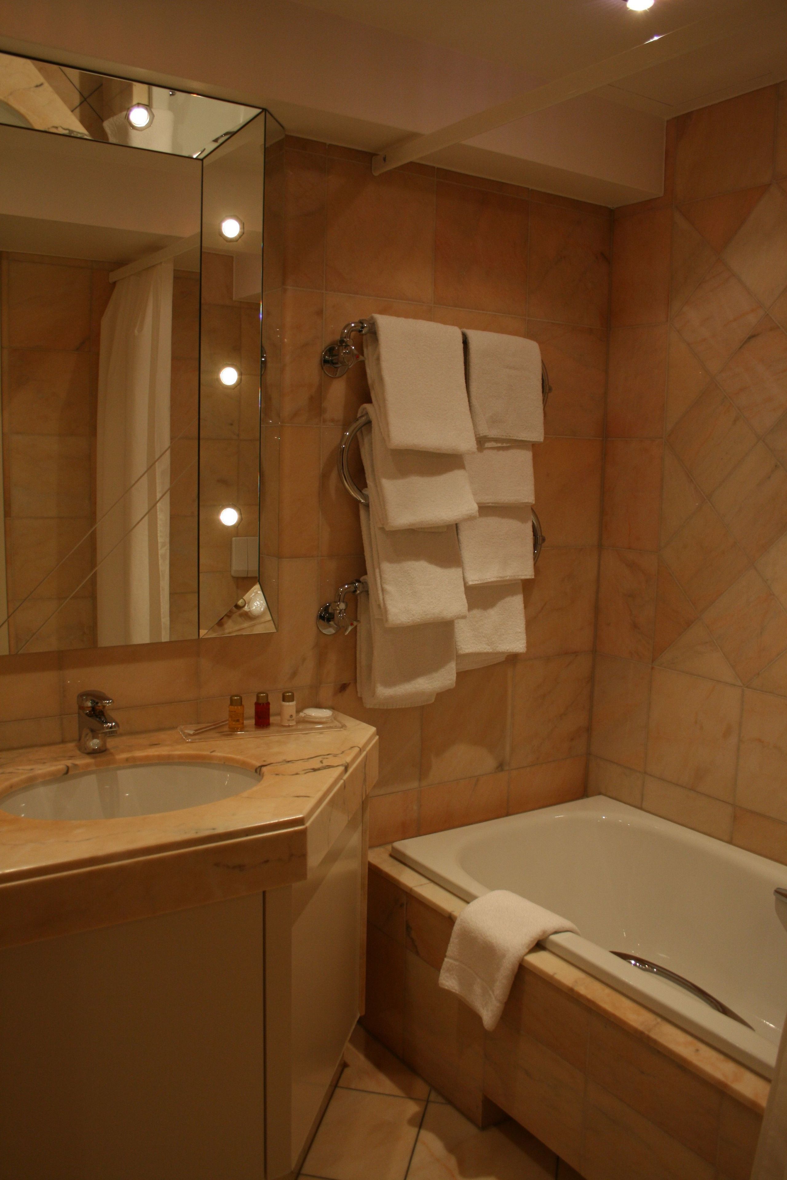 A bathroom with a sink, mirror, and bathtub.