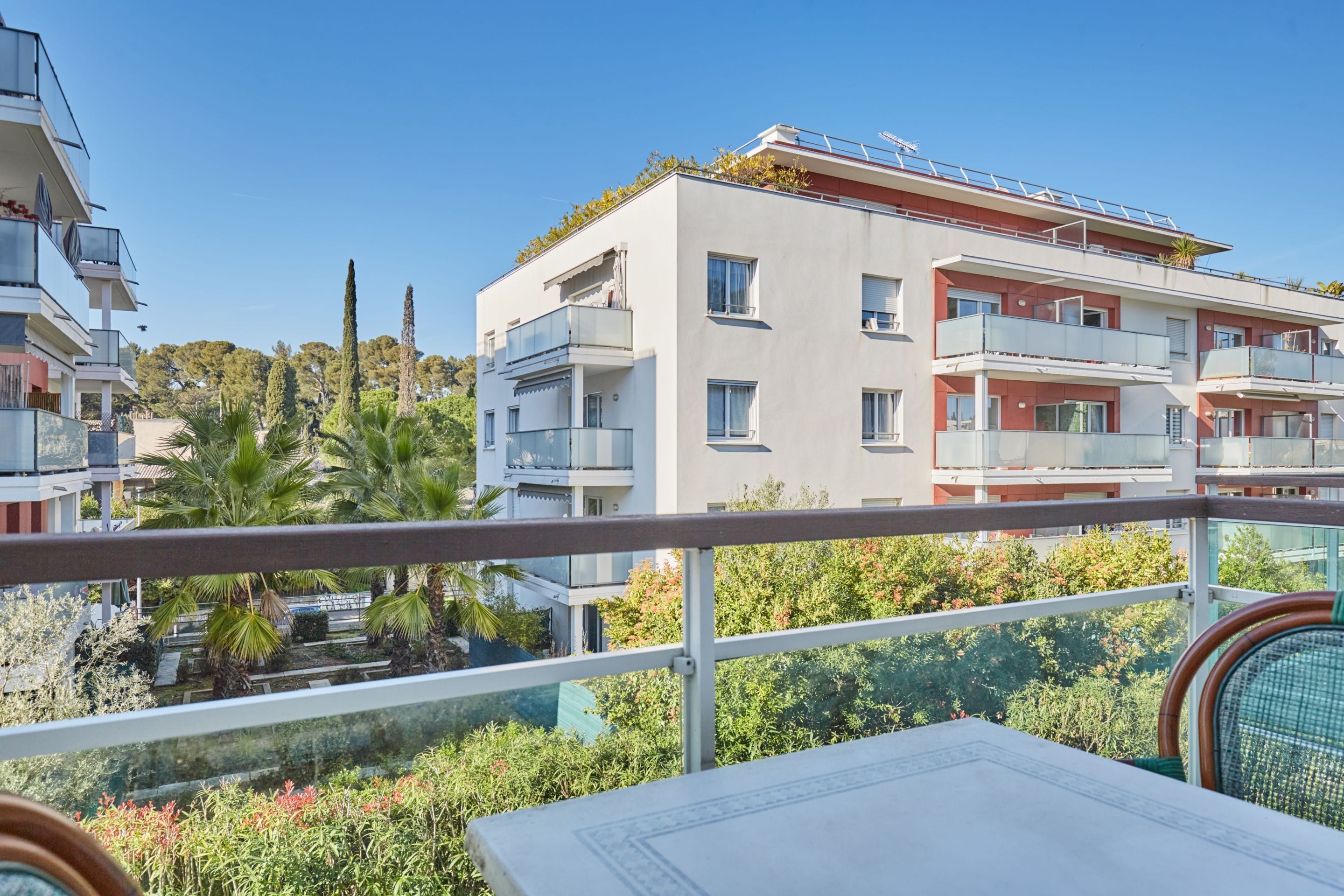 Un moderno edificio de apartamentos con balcones, terraza y vistas a zonas verdes.