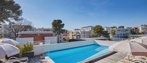 Kauden mukainen ulkouima-allas, aurinkotuoleja