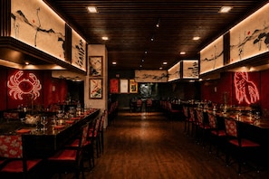 A dimly lit restaurant with wooden floors and tables set for dining. - Ocean Coral Riviera Cancun All Inclusive (Puerto Morelos)