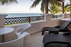 A balcony with a view of the sea, white and dark wicker chairs, and a small table. - Ocean Coral Riviera Cancun All Inclusive (Puerto Morelos)