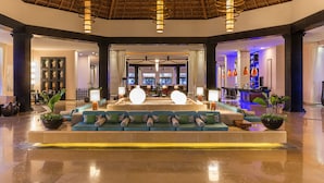 A lobby with a central seating area, a reception desk, and a bar area.