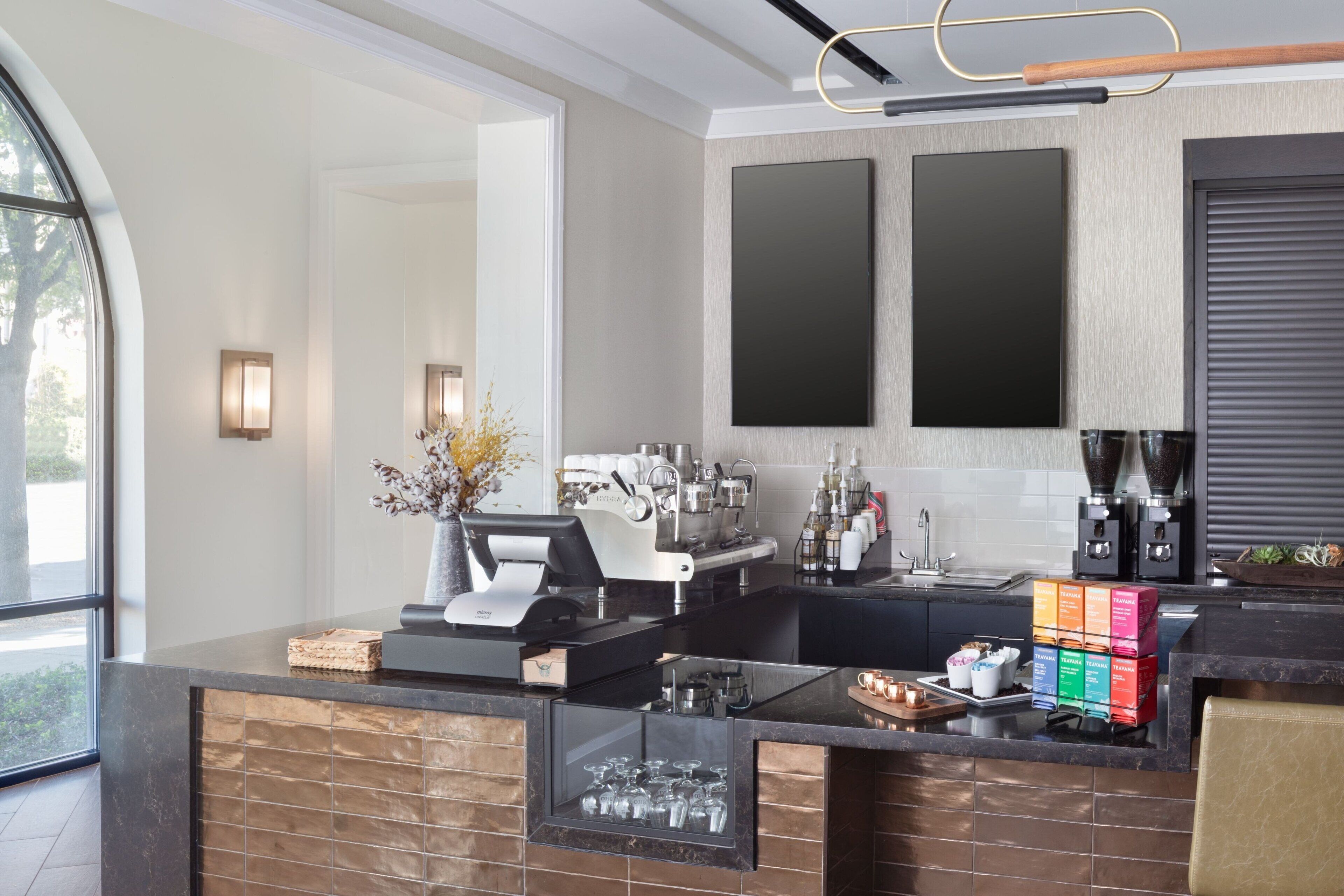 A modern kitchen with a coffee machine, a sink, and a glass display.