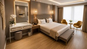 Una habitación de hotel moderna con una cama grande, mesitas de noche, un escritorio, una silla y un ventanal amplio.