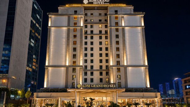 A multi-story hotel with a prominent entrance, large windows, and a well-lit facade. - ADM Grand Hotel (Istanbul)