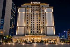 Un hotel de varios pisos con una entrada destacada, ventanas amplias y una fachada bien iluminada.