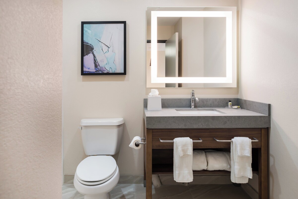 Ein Badezimmer mit Toilette, Waschbecken, Spiegel und Handtuchhalter.
