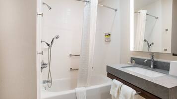 A modern bathroom with a bathtub, shower, and sink.