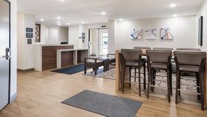 A hotel lobby with a reception desk, seating area, and artwork on the walls. - Candlewood Suites Lake Charles - Sulphur by IHG (Sulphur)