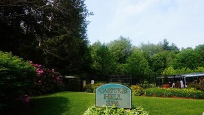 A sign for Castle Hill Spa surrounded by lush greenery and a well-maintained lawn. - Pointe at Castle Hill Resort (Cavendish)