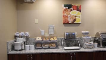 A breakfast buffet with various food items and a coffee machine.