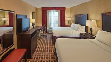 A hotel room with a bed, a desk, a television, a chair, and a telephone.
