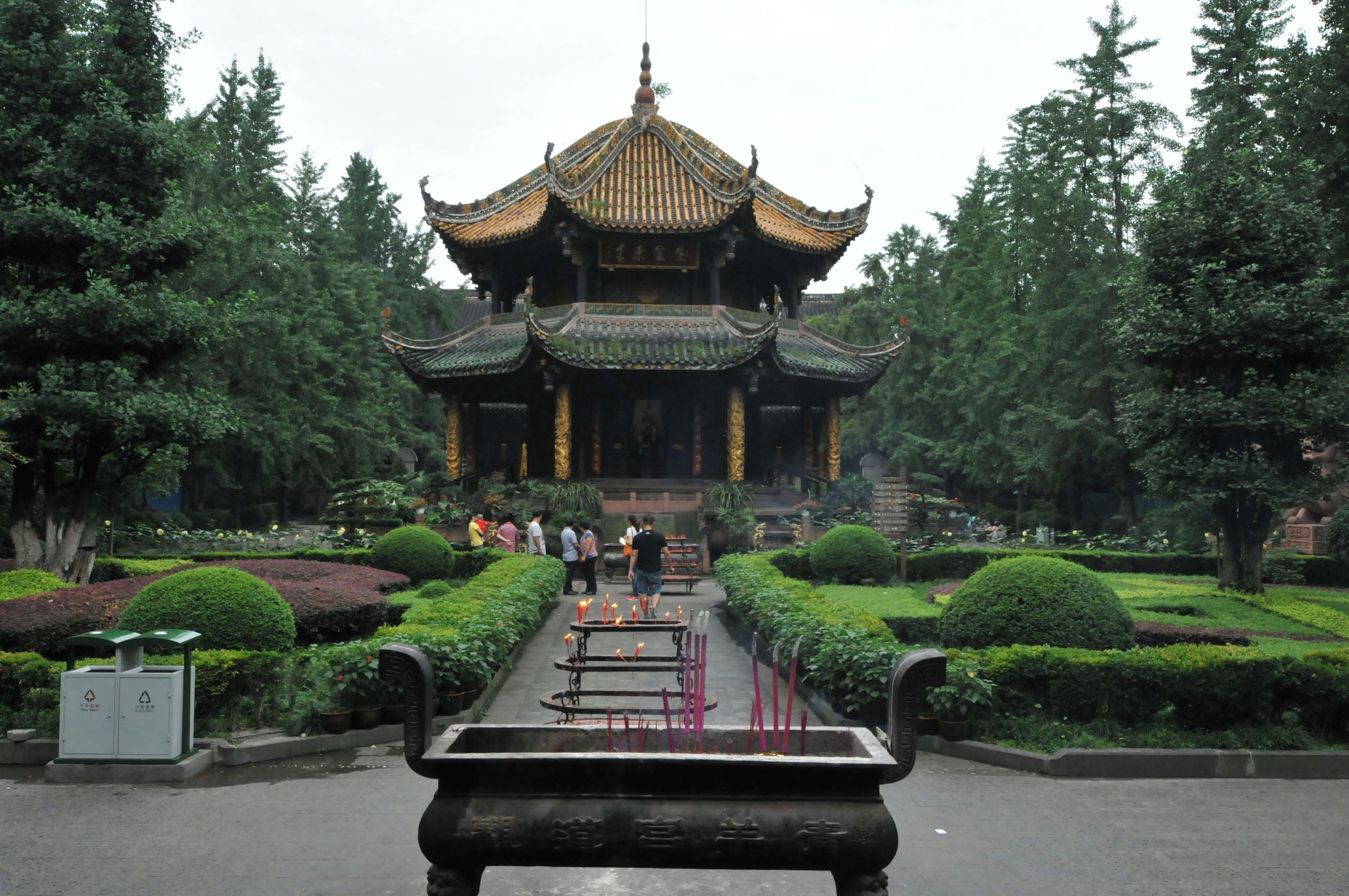 A traditional multi-tiered pagoda with a symmetrical roof design, surrounded by well-manicured gardens and pathways.