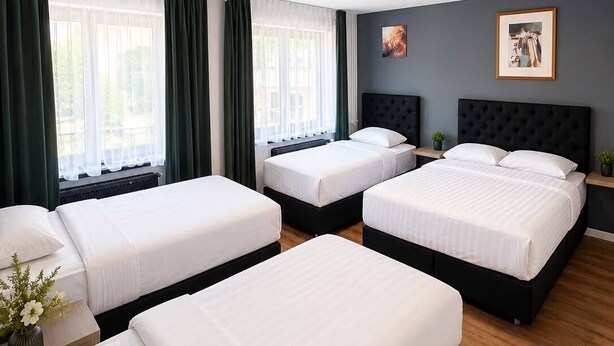 A hotel room with three beds, a ceiling-mounted security camera, and a framed picture on the wall. - Hotel Albergo (Brussels)