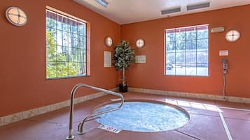 Relax in a serene spa area with a large hot tub and lush views of the surrounding trees.