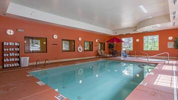 Ein Hallenbad mit roter Wand, einer Sitzgelegenheit und einem Handtuchhalter.