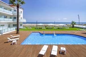 Una piscina al aire libre, sombrillas, tumbonas