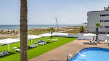 Ein Poolbereich mit freiem Blick auf Strand und Meer.