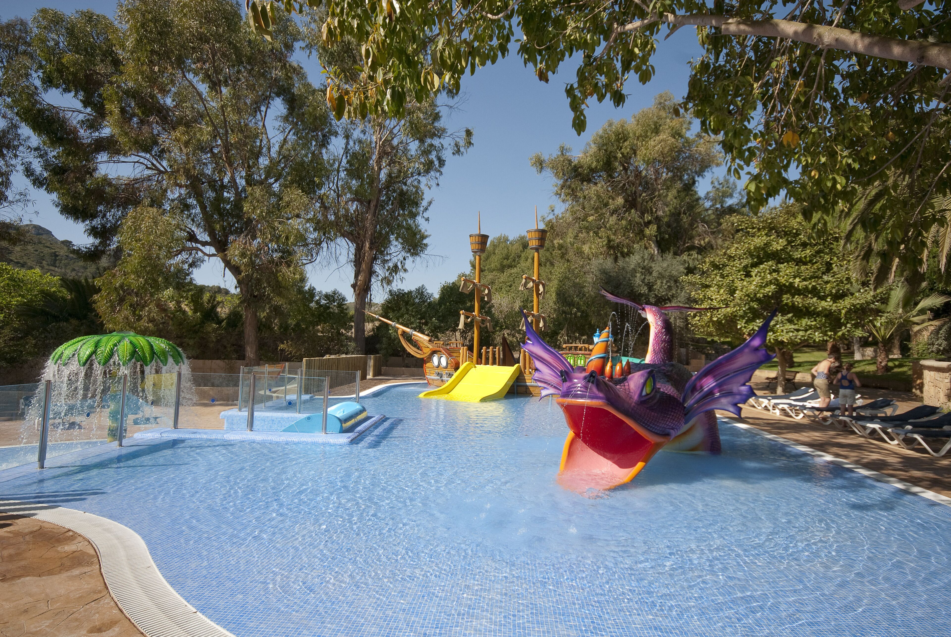A water park with slides and a pool area surrounded by trees.