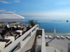 Un restaurante frente al mar con terraza y vistas al océano.