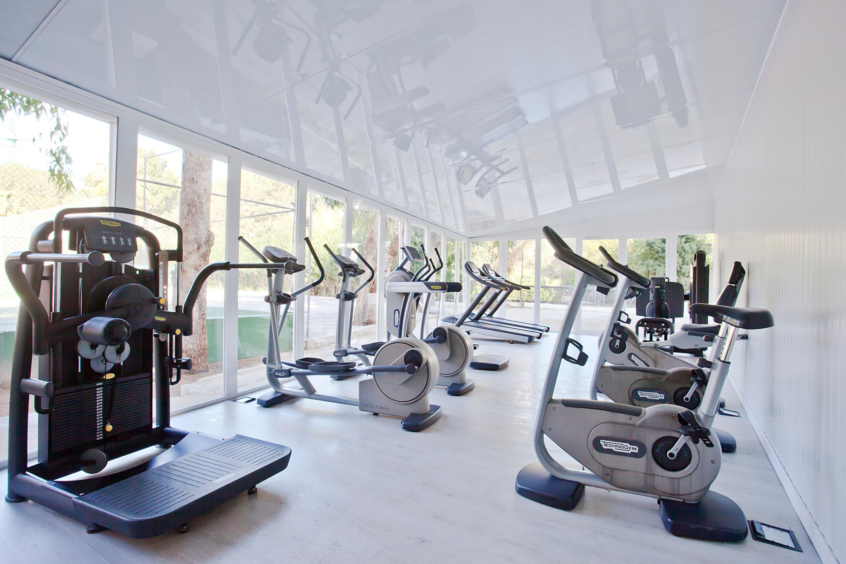 A gym with cardio machines, a rowing machine, and a step platform.