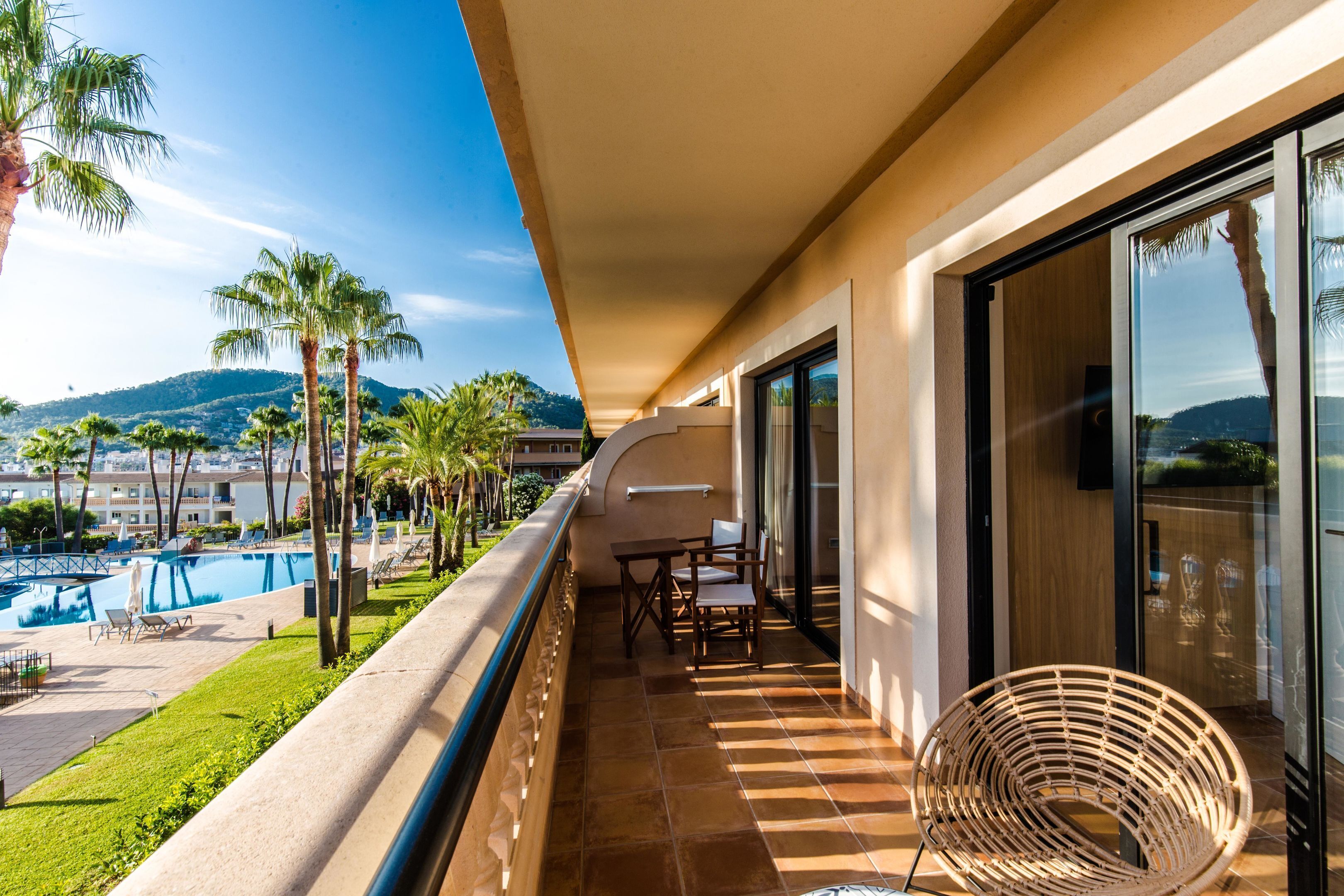 A balcony with a pool view, outdoor furniture, and a chair.