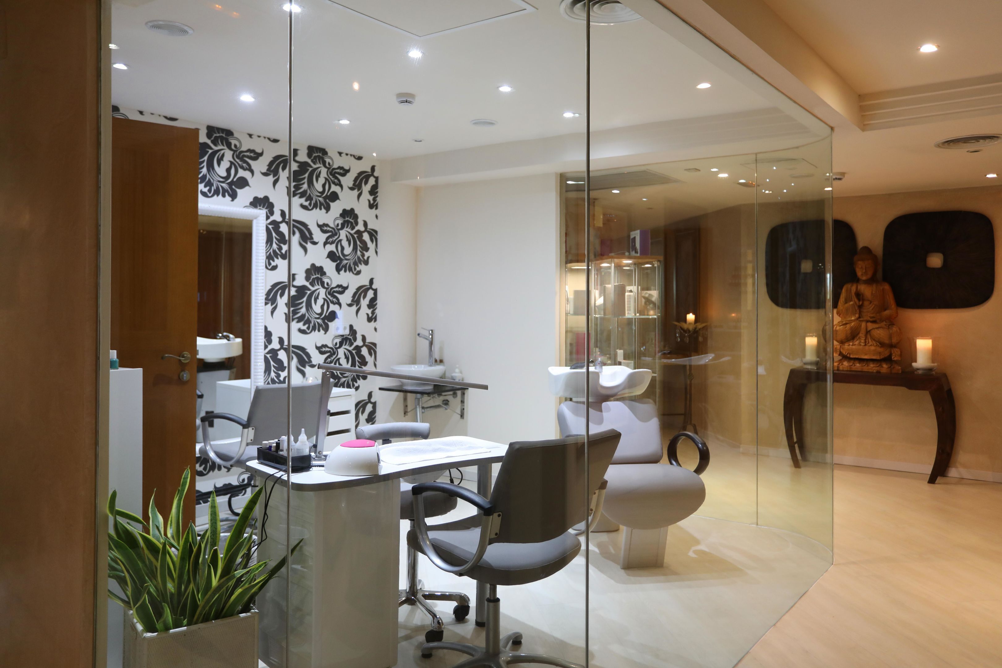 Una clínica dental moderna con zona de recepción, sillones dentales y una estatua de Buda.