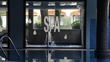 A spa entrance with a water feature, a sign reading 'SPA', and a reflection in the glass.
