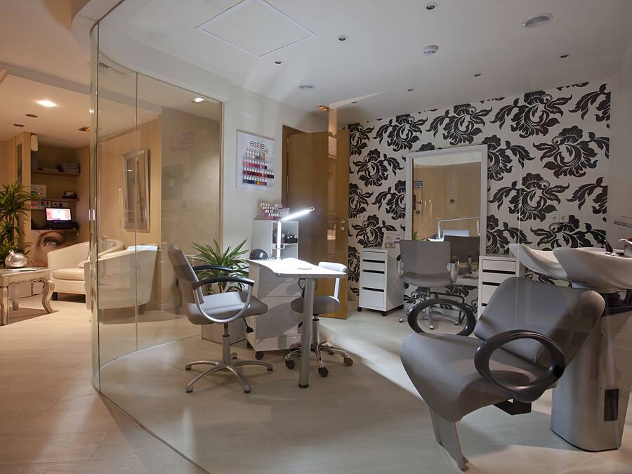 Um consultório dentário moderno com área de recepção, computador, escrivaninha e cadeira odontológica.