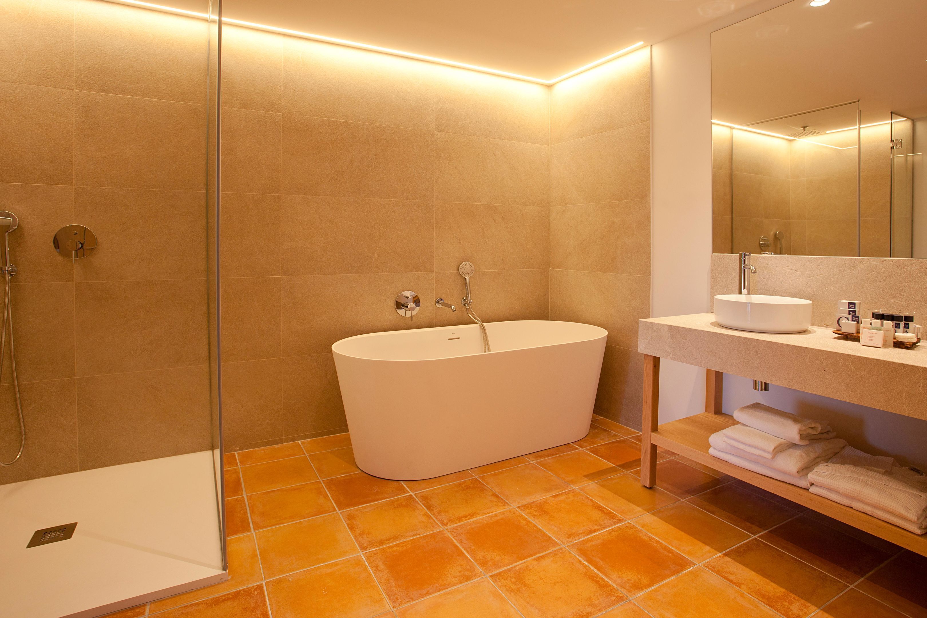 A modern bathroom with a freestanding bathtub, a glass-enclosed shower, and a vanity with a mirror.
