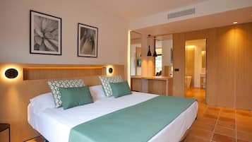 A modern bedroom with a large bed, two wall-mounted lights, and a mirror above the bed.
