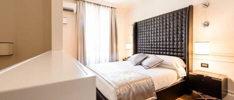 Una habitación de hotel moderna con una cama grande, lámparas de noche y suelo de madera.
