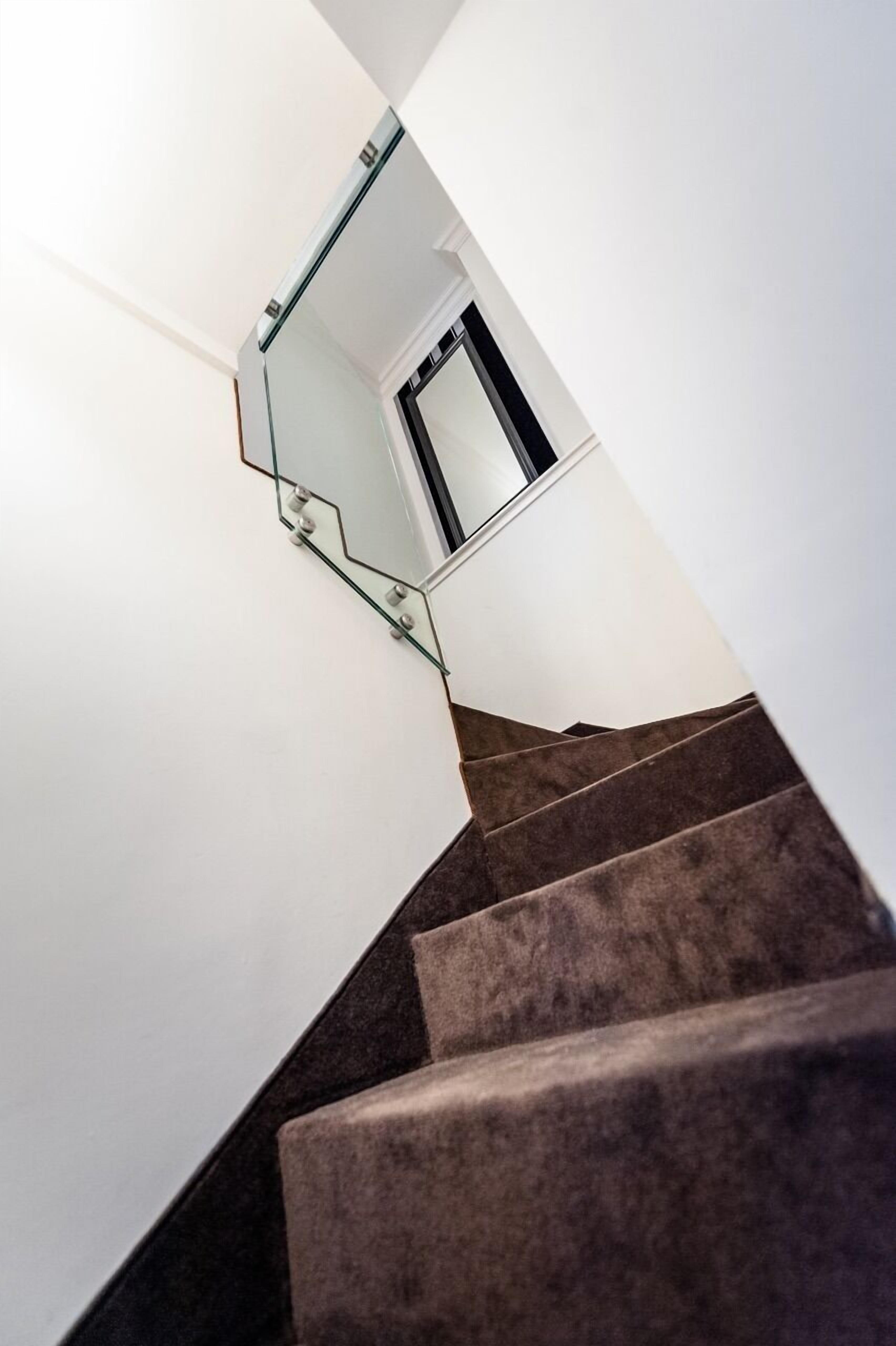 A staircase with a glass railing and a door at the top.